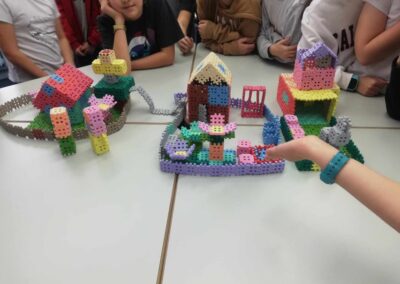 uczniowie budują z klocków domy