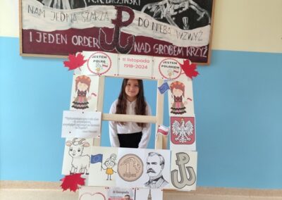 uczniowie w fotobudce z symbolami niepodległej Polski