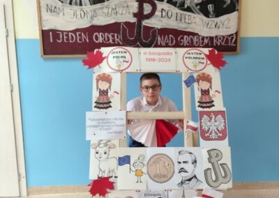 uczniowie w fotobudce z symbolami niepodległej Polski