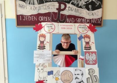 uczniowie w fotobudce z symbolami niepodległej Polski