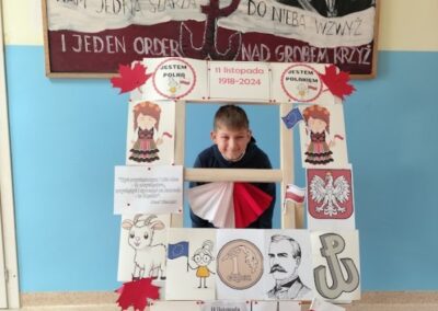 uczniowie w fotobudce z symbolami niepodległej Polski