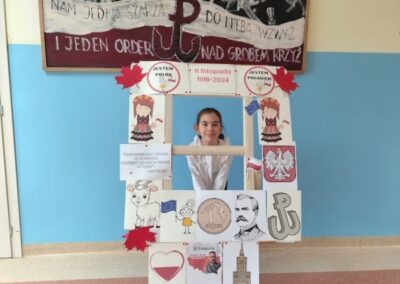 uczniowie w fotobudce z symbolami niepodległej Polski