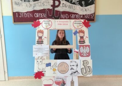 uczniowie w fotobudce z symbolami niepodległej Polski
