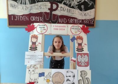 uczniowie w fotobudce z symbolami niepodległej Polski