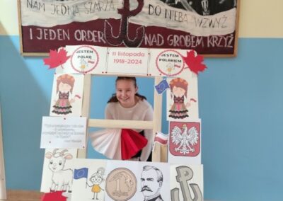 uczniowie w fotobudce z symbolami niepodległej Polski