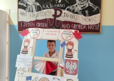 uczniowie w fotobudce z symbolami niepodległej Polski