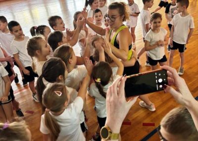 Zajęcia muzyczne zumba uczniowie na hali tańczą w dużej grupie