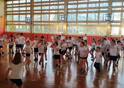 Zajęcia muzyczne zumba uczniowie na hali tańczą w dużej grupie