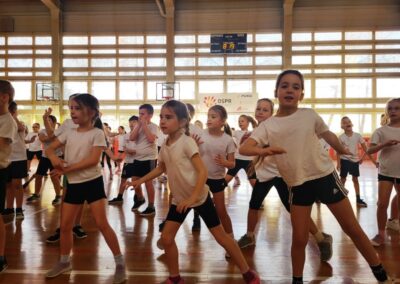 Zajęcia muzyczne zumba uczniowie na hali tańczą w dużej grupie